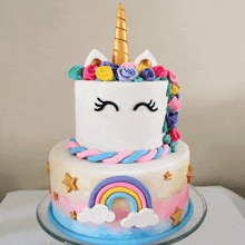 a cake that looks like a unicorn with flowers and a rainbow on it