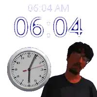 a man with glasses stands next to a clock that says 6:04 am