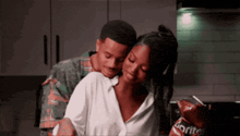 a man is hugging a woman in a kitchen with doritos chips in the background