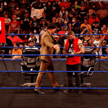 two men in a wrestling ring with one wearing a red shirt that says ' i 'm a true fan '