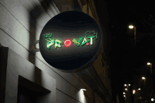 a neon sign on a building that says ' provat ' on it