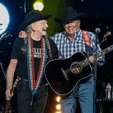 a man wearing a shirt that says willie nelson is standing next to another man holding a guitar