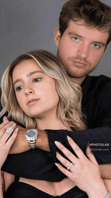 a man and a woman are posing for a photo and the man is wearing a watch on his wrist