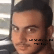 a close up of a man 's face with the words " ne demek mileh yok anne " on the bottom