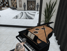 a man with a tattoo on his back sits at a piano