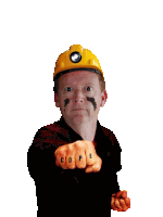 a man wearing a hard hat and a black shirt has the word cope on his fist