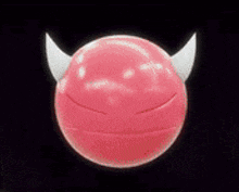 a red ball with horns on it is making a devil face .