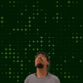 a man with a beard and glasses is looking up at a glowing number 20