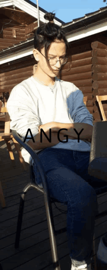 a woman is sitting in a chair with angy written on the bottom