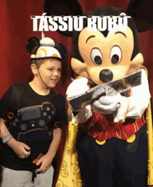 a young boy standing next to a mickey mouse mascot with the words tassiu robo on the bottom