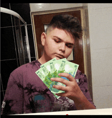 a man holding a bunch of 1 leu bills in front of a mirror