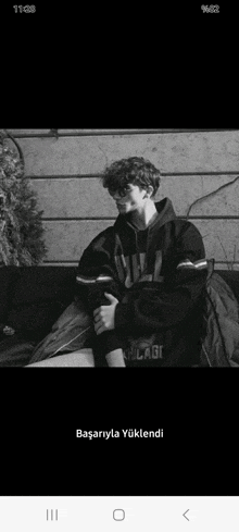 a black and white photo of a young man wearing a chicago hoodie