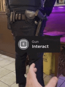 a person is pointing at a person with a gun on their back and the word gun interact is on the screen