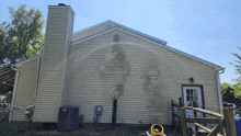 the back of a house with a chimney on top