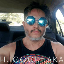 a man wearing sunglasses and a shirt that says hugogubaka