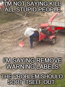 a man with a shovel standing next to a tractor with a warning label on it