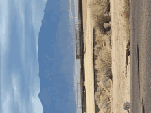 a road with mountains in the background and a sign that says ' i 'm sorry '