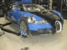 a blue bugatti veyron is sitting on top of a garage floor .