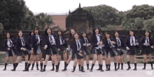 a group of girls in school uniforms are dancing in front of a building that says drop hat on it