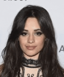 a close up of a woman 's face with long hair and a choker around her neck .