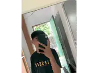 a young man taking a picture of himself in a mirror wearing a black shirt with the number 13231 on it
