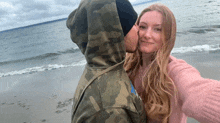 a man kisses a woman on the cheek on the beach