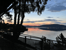 a view of a lake at sunset with mountains in the background