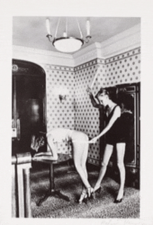 a black and white photo of two women in a room with polka dots on the wall