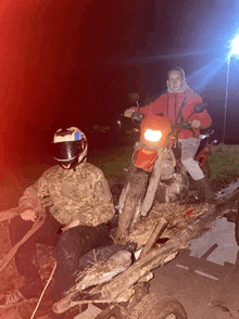 a man wearing a helmet sits next to a motorcycle