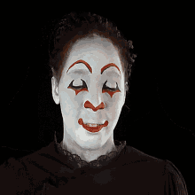 a woman with a clown makeup on her face is giving two thumbs up