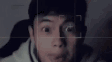 a blurry picture of a man 's face with a camera looking at it .