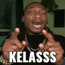 a man wearing a black shirt and a gold chain is making a funny face with the word kelass on it