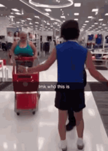 a man in a blue shirt is standing in front of a woman pushing a shopping cart in a target store ..