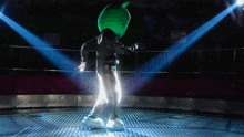 a person in a green costume is dancing in front of a crowd