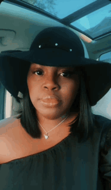 a woman wearing a black hat and a necklace is sitting in a car