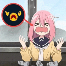 a girl with pink hair is crying while sitting at a table with a can of soda in front of her .