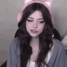 a girl wearing a cat ear headset is sitting in a chair .