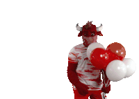 a red bull mascot is holding balloons in front of his face