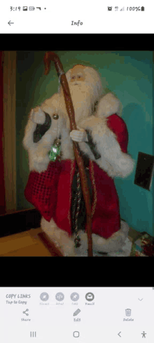 a phone screen shows a picture of santa claus with a cane