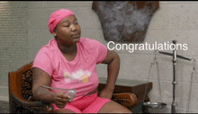 a woman in a pink shirt says congratulations while smoking