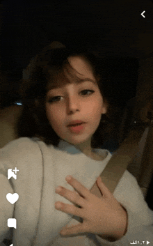 a girl is taking a selfie in a car with arabic writing on the bottom right