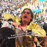a man in a yellow jacket is yelling at a woman at a sports game
