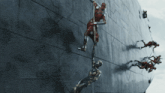 a man in a red suit is hanging from a rope on a wall