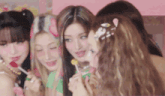 a group of girls are eating lollipops together .