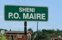 a green sign that says " sheni p.o. maire " on it