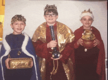 three boys dressed as the three wise men holding gifts