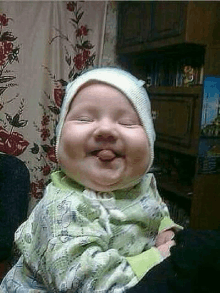 a baby with a bandage on his head is making a funny face while being held by a person .