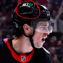 a hockey player wearing a helmet that says bet 99