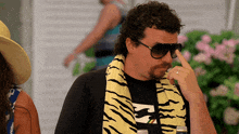 a man wearing a billabong shirt and a tiger print scarf
