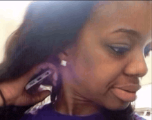 a woman is talking on a cell phone while wearing earrings